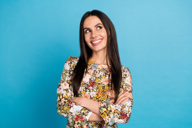 照片肖像可爱的年轻女士交叉双手看空空间穿着时尚的花朵印花服装孤立在蓝色的背景图片下载