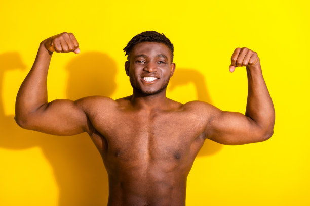 有吸引力的好男人的照片，没有衣服，强壮的身体，显示手臂孤立的黄色背景图片下载