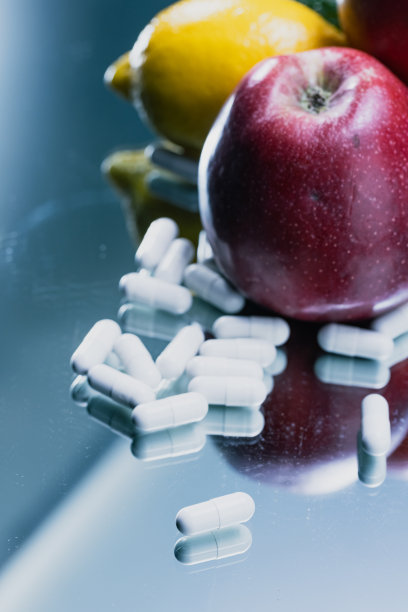 白色胶囊和水果在反射表面-药品药丸的特写-库存照片图片下载