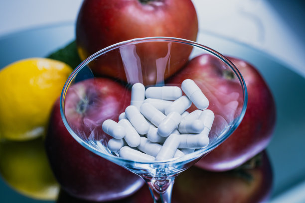 彩色水果与药丸在蓝色背景上的玻璃杯-健康概念-库存照片图片下载