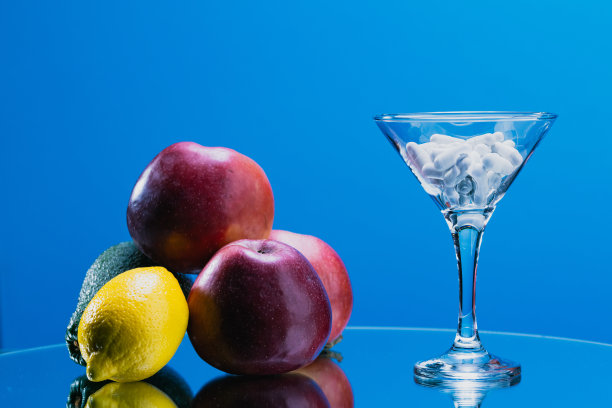 彩色水果与药丸在蓝色背景上的玻璃杯-健康概念-库存照片图片下载