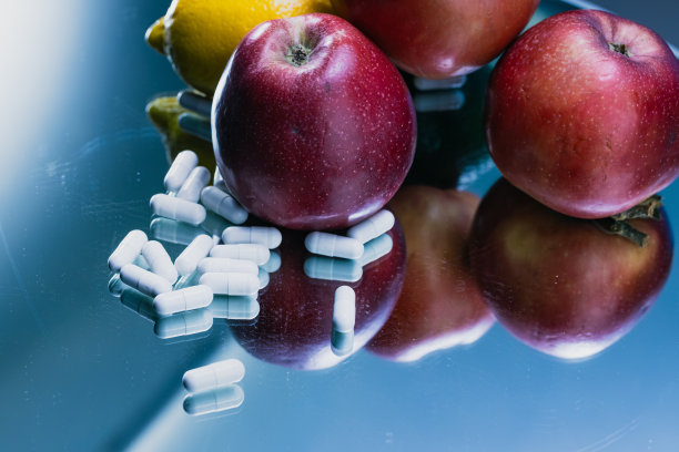 白色胶囊和水果在反射表面-药品药丸的特写-库存照片图片下载