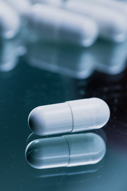 反光表面的白色胶囊-药物药丸特写-库存照片图片下载