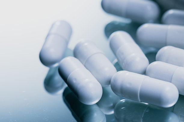 反光表面的白色胶囊-药物药丸特写-库存照片图片下载