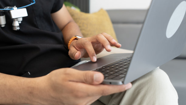 (特写)牙医在办公室里使用笔记本电脑图片下载