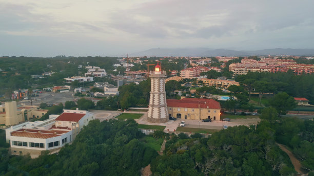 高灯塔闪烁多云的夜空无人机拍摄。城市中的现代灯塔图片下载