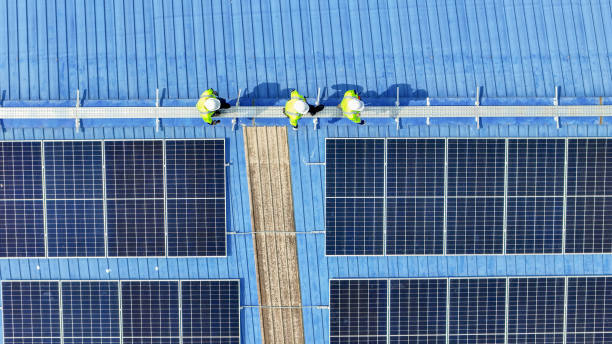 工程师用电子设备检查太阳能电池板或光伏电池的结构。工业可再生能源的绿色动力。在塔顶工作的工人。图片下载