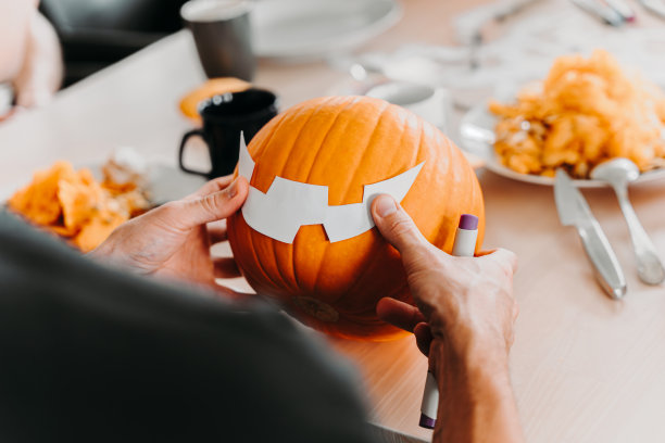 一个人在南瓜上涂模板，准备万圣节雕刻图片下载