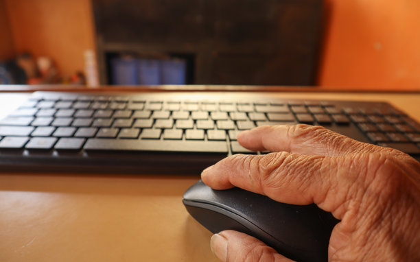 人类手指操作电脑无线鼠标的特写图片。图片下载