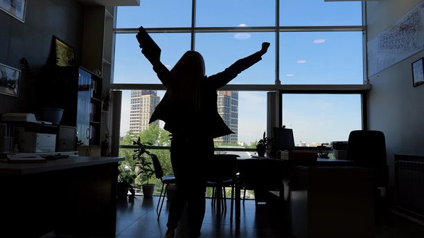 在办公室高举双臂的人的剪影胜利专业成功事业胜利。办公室的人剪影手臂举起庆祝事业成功成就胜利喜悦自信。图片下载