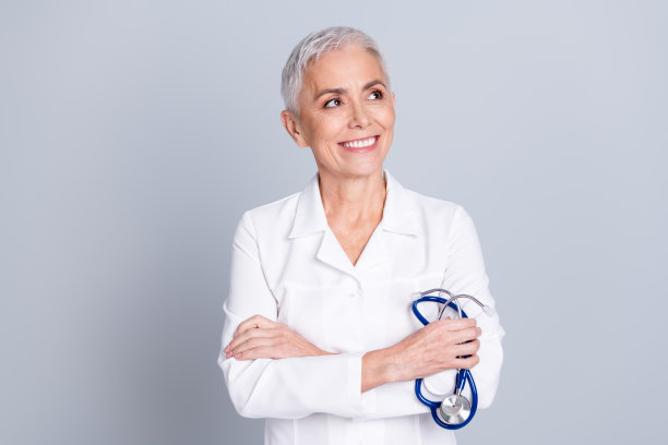 照片中迷人迷人的专科医生女人穿着白色长袍工作在健康中心空旷的空间孤立的灰色背景图片下载