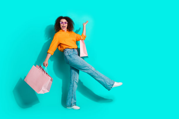 全尺寸照片的有趣的女人穿着衬衫拿着购物袋手臂展示产品的空白空间孤立的蓝绿色背景图片下载