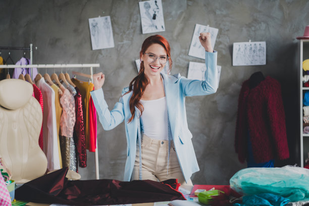 照片漂亮优雅的服装设计师女人举起拳头阁楼室内办公室在室内图片下载