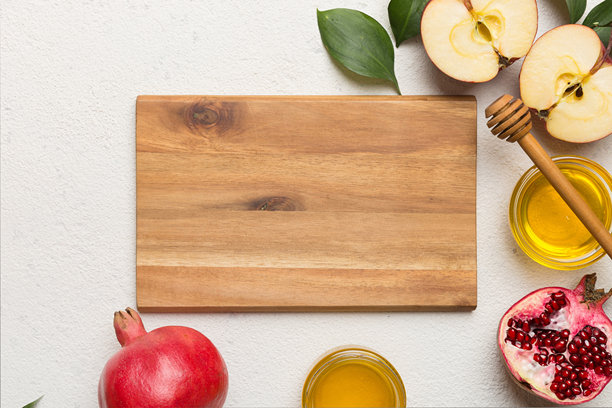 犹太新年，概念:蜂蜜，苹果和石榴与砧板，近距离图片下载