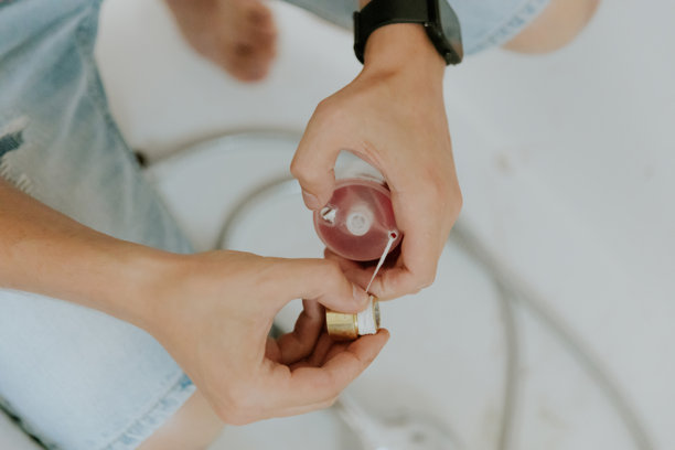 一个年轻人用绳子缠住浴室水龙头的螺帽。图片下载