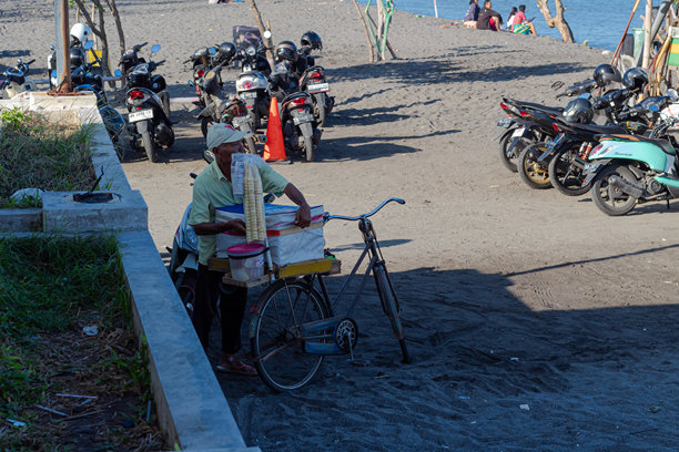 2024年7月14日，印尼龙目岛，一名冰淇淋小贩骑着自行车在龙目岛的Loang Baloq海滩上卖冰淇淋图片下载