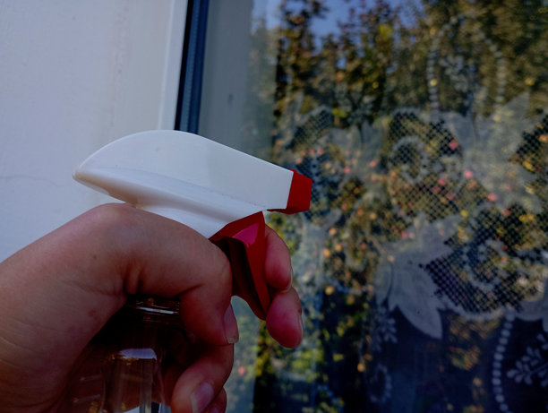 使用安装在液体罐上的特殊喷雾器将窗户清洁剂喷洒到玻璃表面。用特殊工具清洗窗户的过程。图片下载