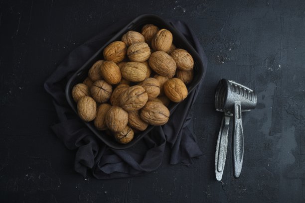 碎核桃和胡桃钳黑色背景图片下载