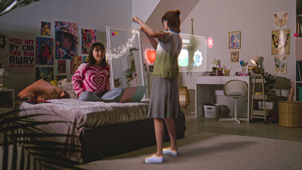 十几岁的女孩坐在床上与虚拟现实全息图聊天图片下载