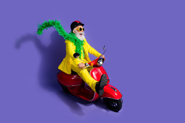 照片中开朗的留着大胡子的时髦的退休老人穿着黄色时髦的服装旅行，在紫色的背景上看起来很空旷图片下载