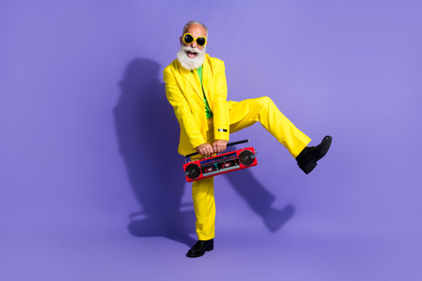 疯狂的积极有趣的时尚男人的照片，穿着黄色的时尚服装，在紫色的背景上听音乐图片下载