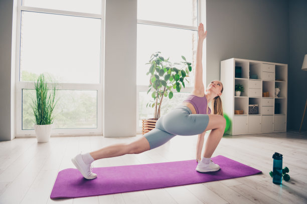 可爱的运动活跃的女孩穿着运动服在家里做瑜伽练习的照片图片下载