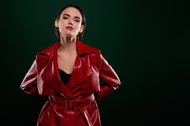 照片中优雅的女孩看起来穿着时髦的衣服，站在空旷的空间孤立的深色背景图片下载