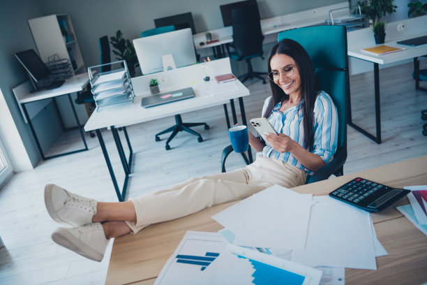 女人的全身照片休息放松拿着装置喝咖啡穿着条纹正装舒适的光启动办公室室内图片下载