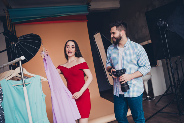 英俊的男造型师摄影师与模特在工作室为照片制作服装图片下载