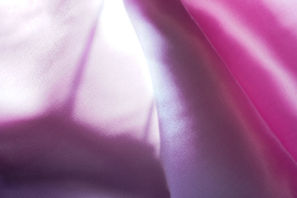 这张照片展示了粉红色绸缎的褶皱从不同的角度反射光线，有美丽的渐变和反射。图片下载