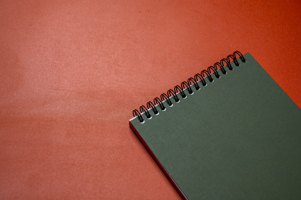 一个红色背景的螺旋笔记本图片下载