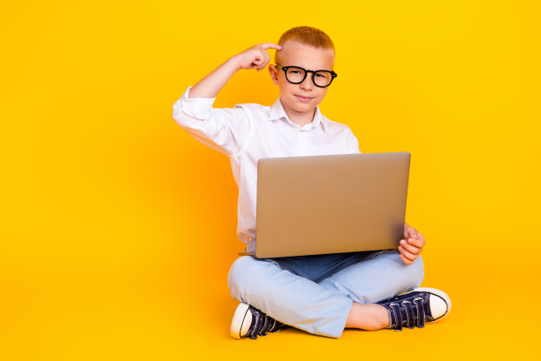 聪明聪明的男孩穿着白衬衫坐在地板上摸着头的照片决定孤立在黄色的背景上图片下载