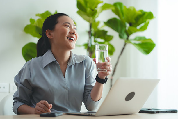 坐在家里办公室喝水休息的亚洲女性。图片下载