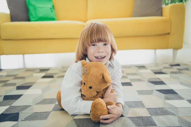 照片迷人可爱有趣开朗的小男孩躺在地板地毯舒适的房子日光室内图片下载