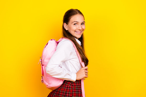 照片肖像迷人的十几岁的小学生女孩双肩包购物穿时髦的制服孤立在黄色的背景图片下载