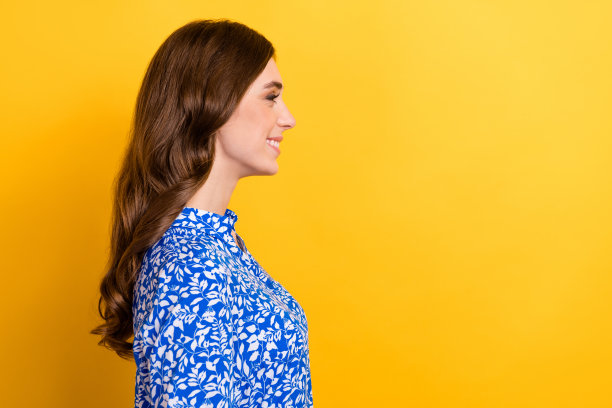 侧面照片的漂亮可爱的积极的女士示范美发后，美容程序孤立的黄色背景图片下载