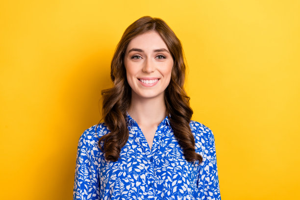 年轻的肖像照片微笑满意的棕色卷发经理雇主女人穿蓝色衬衫正式制服孤立在黄色背景图片下载