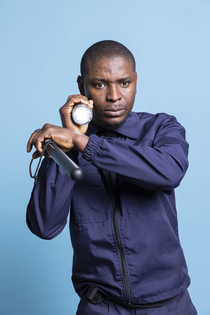 严肃的安全人员在黑暗中用手电筒进行控制扫描图片下载