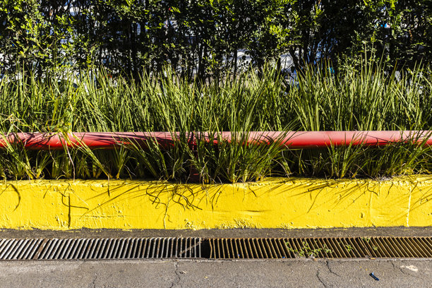 黄色的小墙，红色的管子和小草图片下载