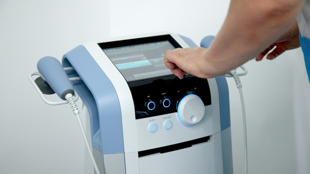 理疗师使用先进设备进行电磁疗法治疗背痛，展示有效的疼痛管理和康复技术图片下载