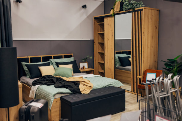 百货公司展示的现代卧室，一张带很多枕头的舒适床，旁边还有一个衣柜图片下载