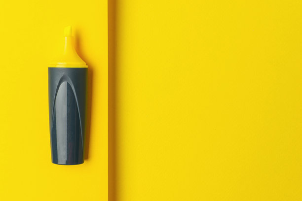 黄色荧光笔在固体黄色背景-极简主义办公用品照片图片下载