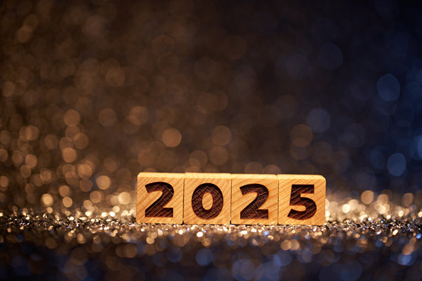 在金色和蓝色散景灯闪闪发光的背景下，展示2025年的木块，营造出节日和优雅的新年氛围。图片下载