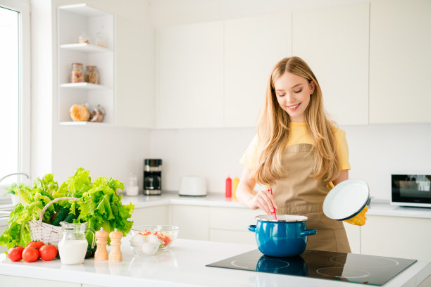 可爱女孩在白色厨房里烹饪美食晚餐照片图片下载