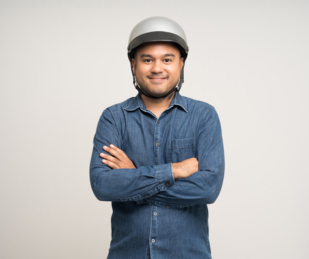 年轻骑手男子在骑摩托车前戴着安全帽。安全的旅程。图片下载