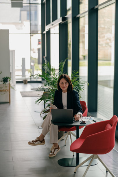 一位年轻的职业女性正专注于在现代办公环境中使用笔记本电脑工作图片下载