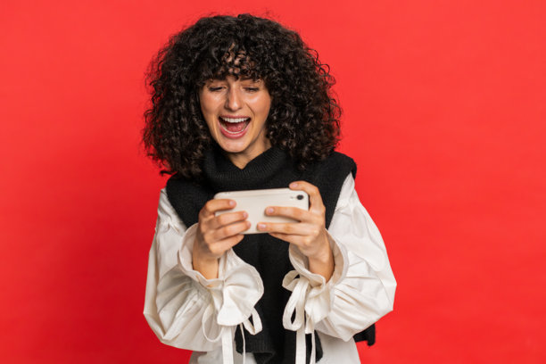 快乐的女人在智能手机上玩赛车模拟射击视频游戏，庆祝胜利图片下载