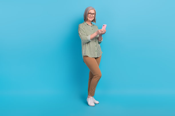 欢乐的新苹果iphone智能手机养老金领取者的全身照片第一个小工具用户广告应用程序隔离在蓝色背景图片下载
