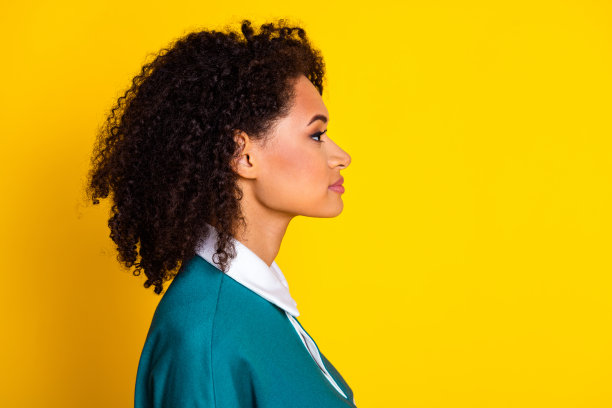 照片中漂亮的年轻女孩看起来空无一人的轮廓，穿着时髦的条纹装，孤立在黄色的背景上图片下载