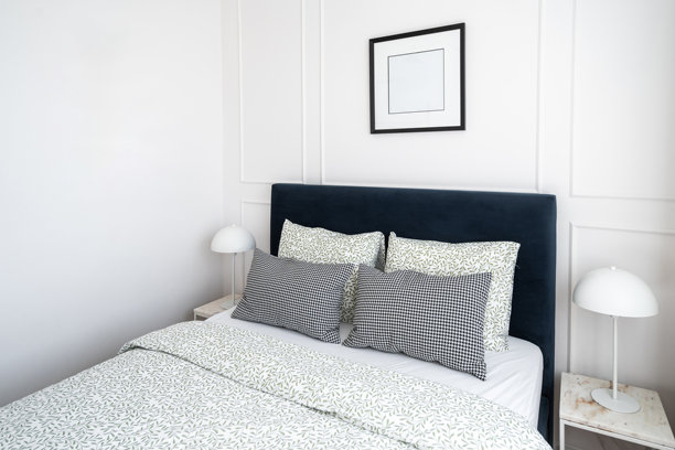 舒适的卧室与现代装饰特色的蓝色床头板和时尚的床上用品图片下载
